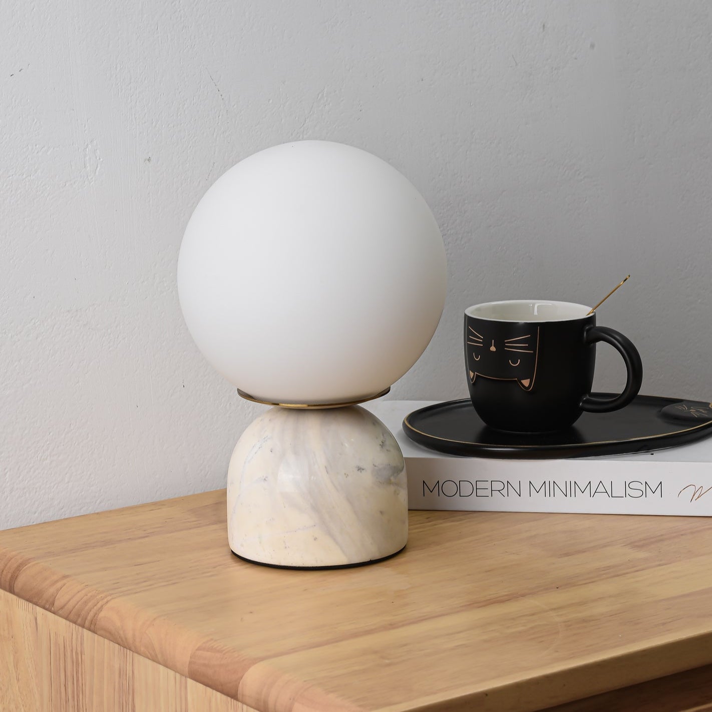 Glass orb table lamp casting warm light in a styled room