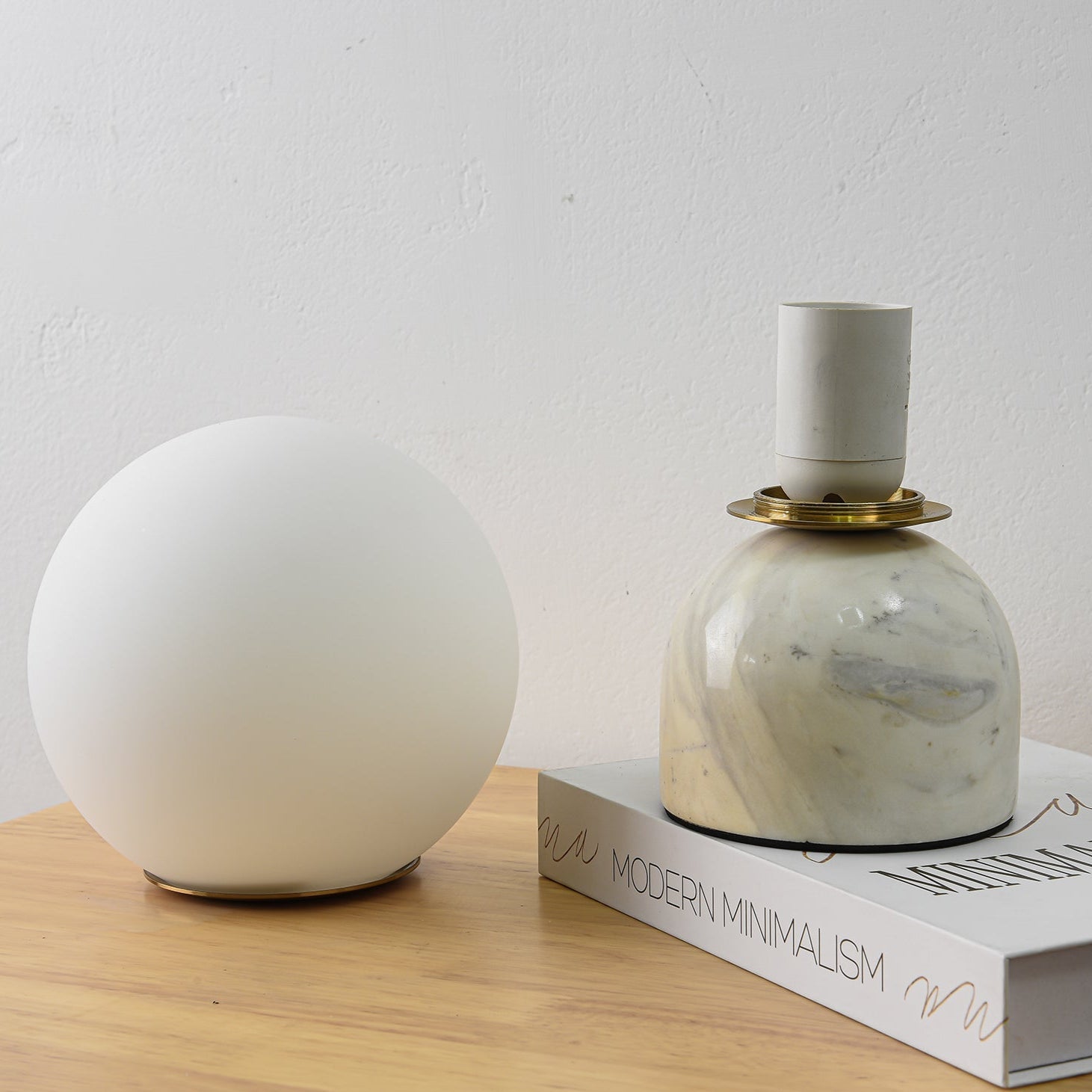 Sylas marble table lamp shown lit on a bedside table