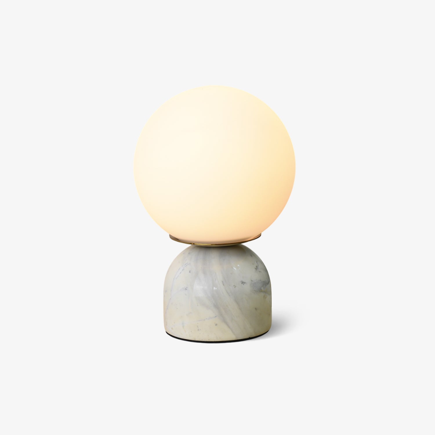 White glass orb table lamp on a green marble base