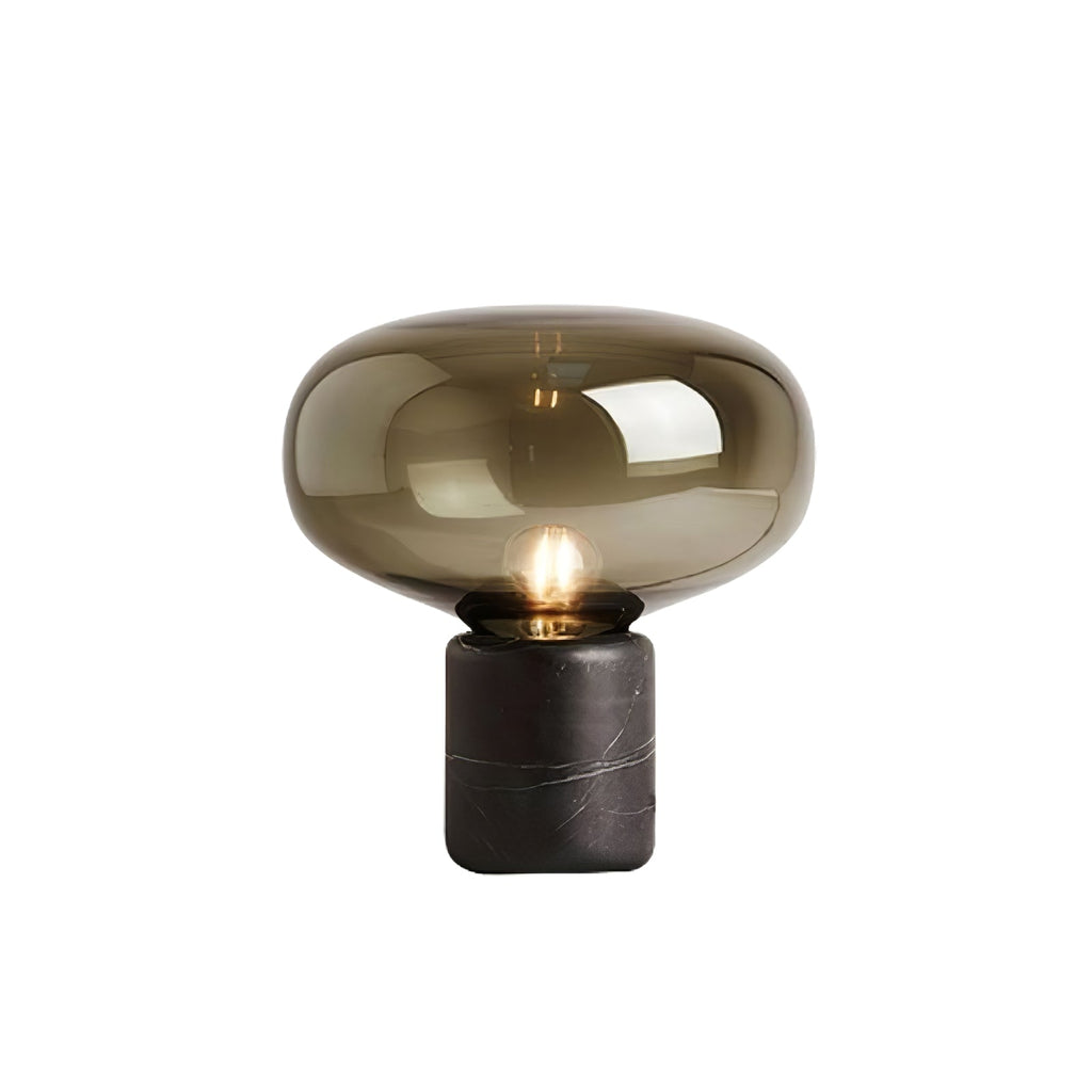 A studio shot of the amber-glass Clérachic table lamp on white, showing the full silhouette from a slight angle.