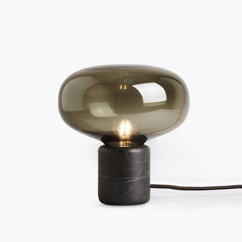 A closer studio crop of the Clérachic table lamp on white, the smoke-grey dome and filament bulb centred in frame.