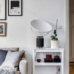 White bowl table lamp lit on a wooden surface