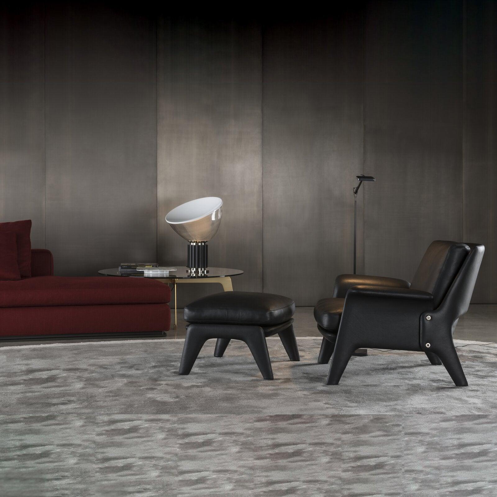 Aluminum table lamp lit beside seating in living space