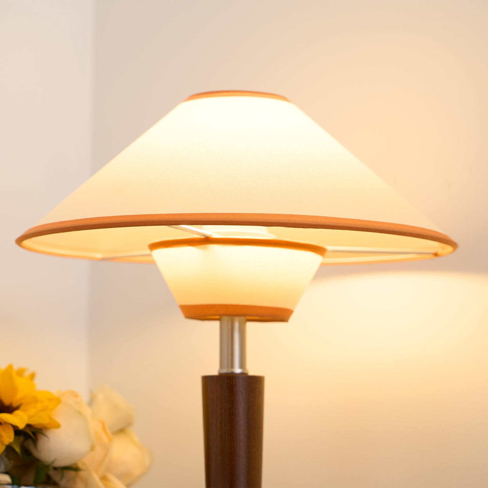 Green fabric table lamp with walnut base on a wooden desk
