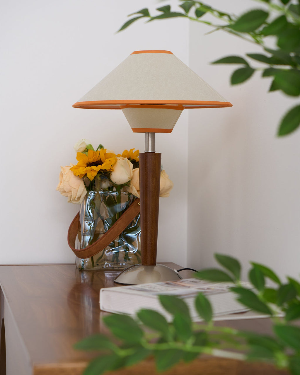 Walnut wood table lamp with fabric shade beside a sofa