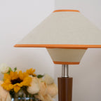 Walnut wood table lamp with fabric shade in a warm interior