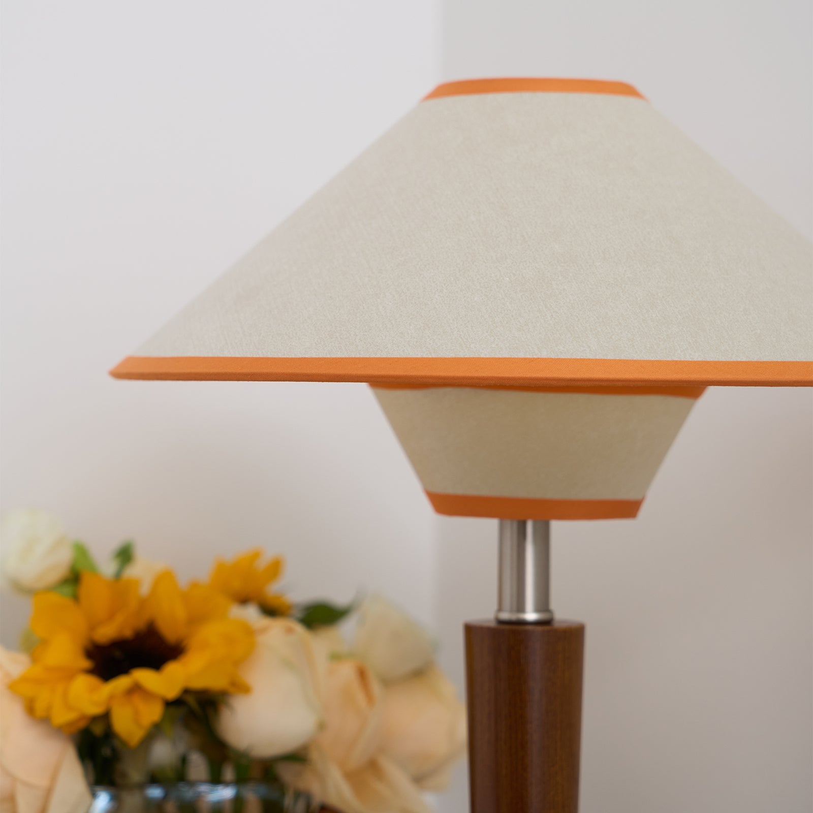 Walnut wood table lamp with fabric shade in a warm interior