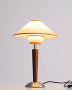 Fabric shade lamp on walnut base lighting a calm corner
