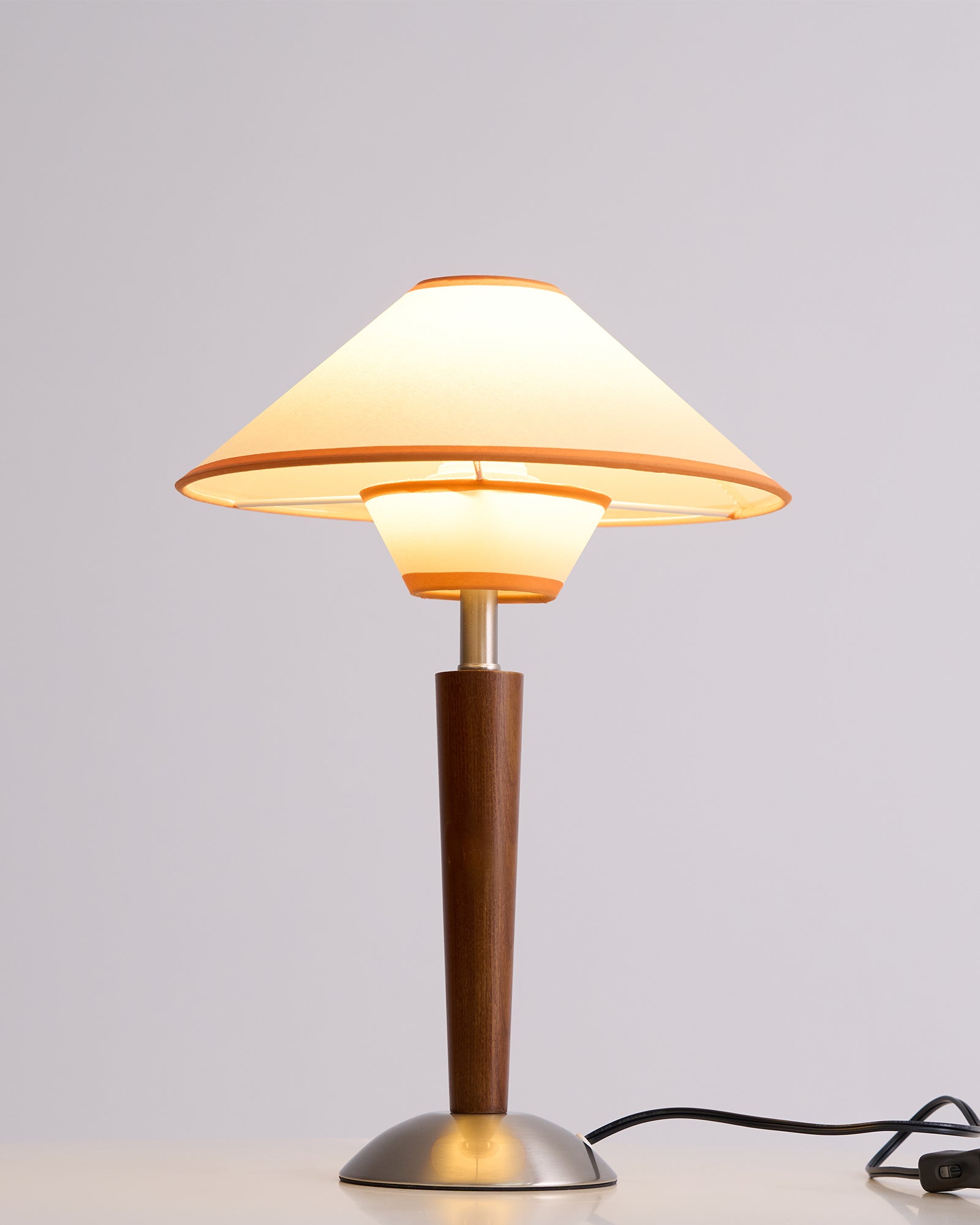 Fabric shade lamp on walnut base lighting a calm corner