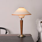 Fabric shade table lamp detail showing warm light and walnut base