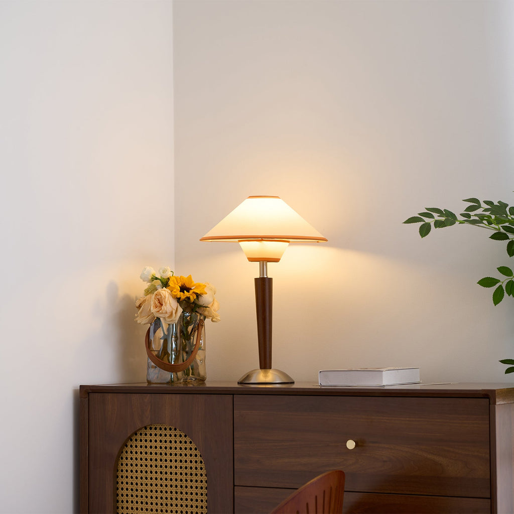 Green fabric shade table lamp glowing on a living room table