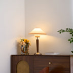 Green fabric shade table lamp glowing on a living room table