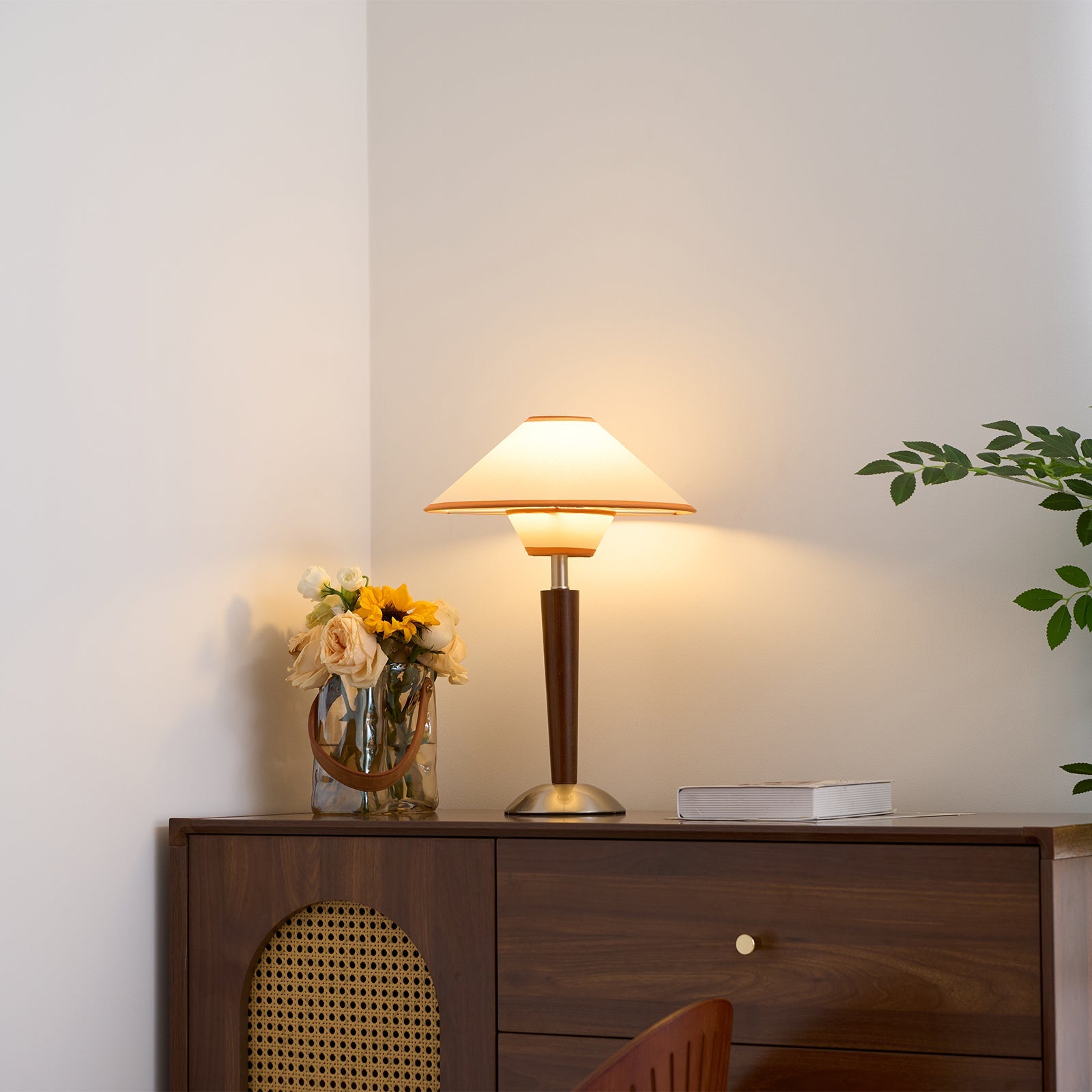 Green fabric shade table lamp glowing on a living room table