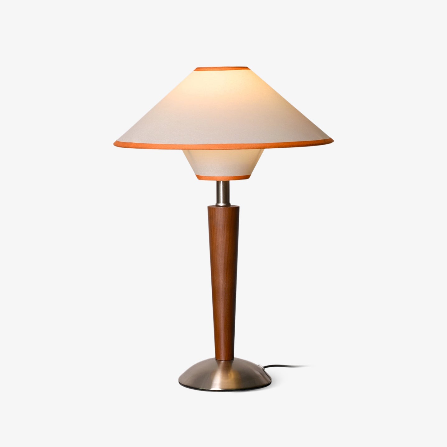 Table lamp with soft fabric shade glowing on a nightstand