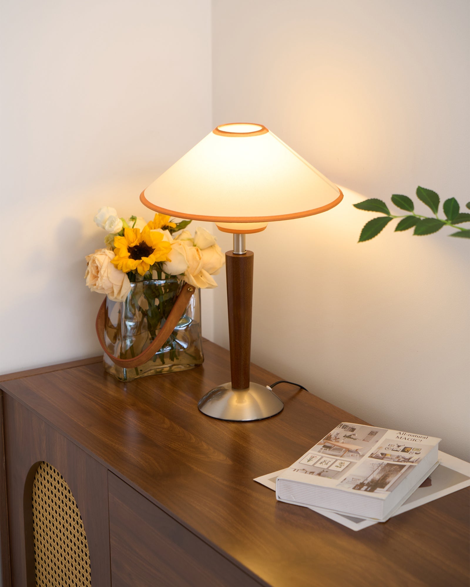 Beige fabric shade table lamp casting warm light at a bedside