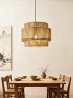 Hung above a rustic wood dining table, this Clérachic pendant catches the light near a hanging ink-wash scroll painting.
