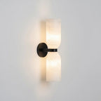 Black and white alabaster column sconce casting soft ambient light