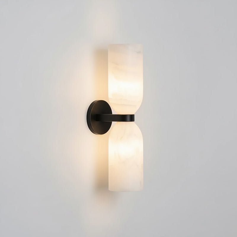 Black and white alabaster column sconce casting soft ambient light