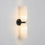 Twin alabaster column wall light in black finish with warm glow