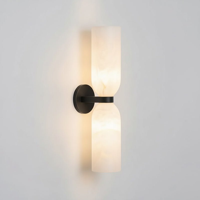 Twin alabaster column wall light in black finish with warm glow