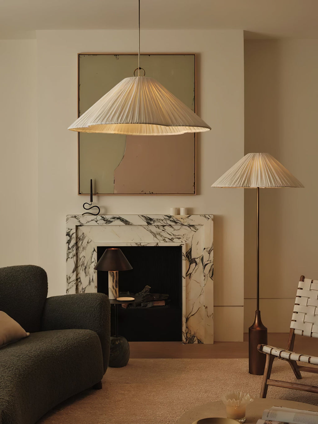 Clérachic pleated white pendant and floor lamp with a brass bottle base glow beside a marble fireplace and dark sofa.