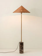 Shown full length on a plain white background, a Clérachic rattan cone-shade floor lamp stands on its dark marble cylinder base.