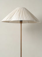 Clérachic pleated white cone-shade floor lamp shown full length on its brass stem against a plain light grey background.