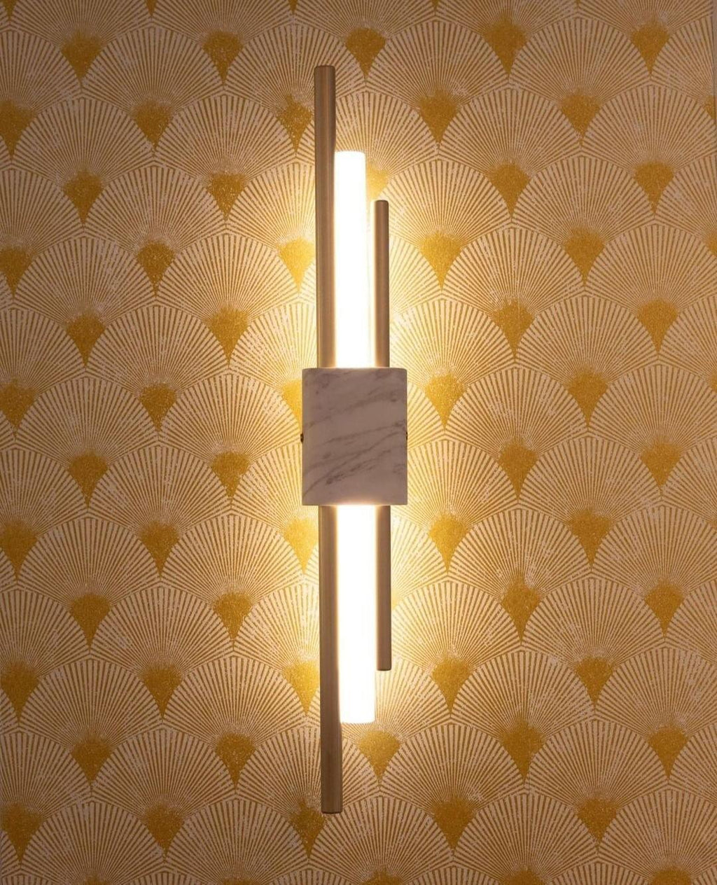 Marble wall lamp casting warm uplight on a hallway wall