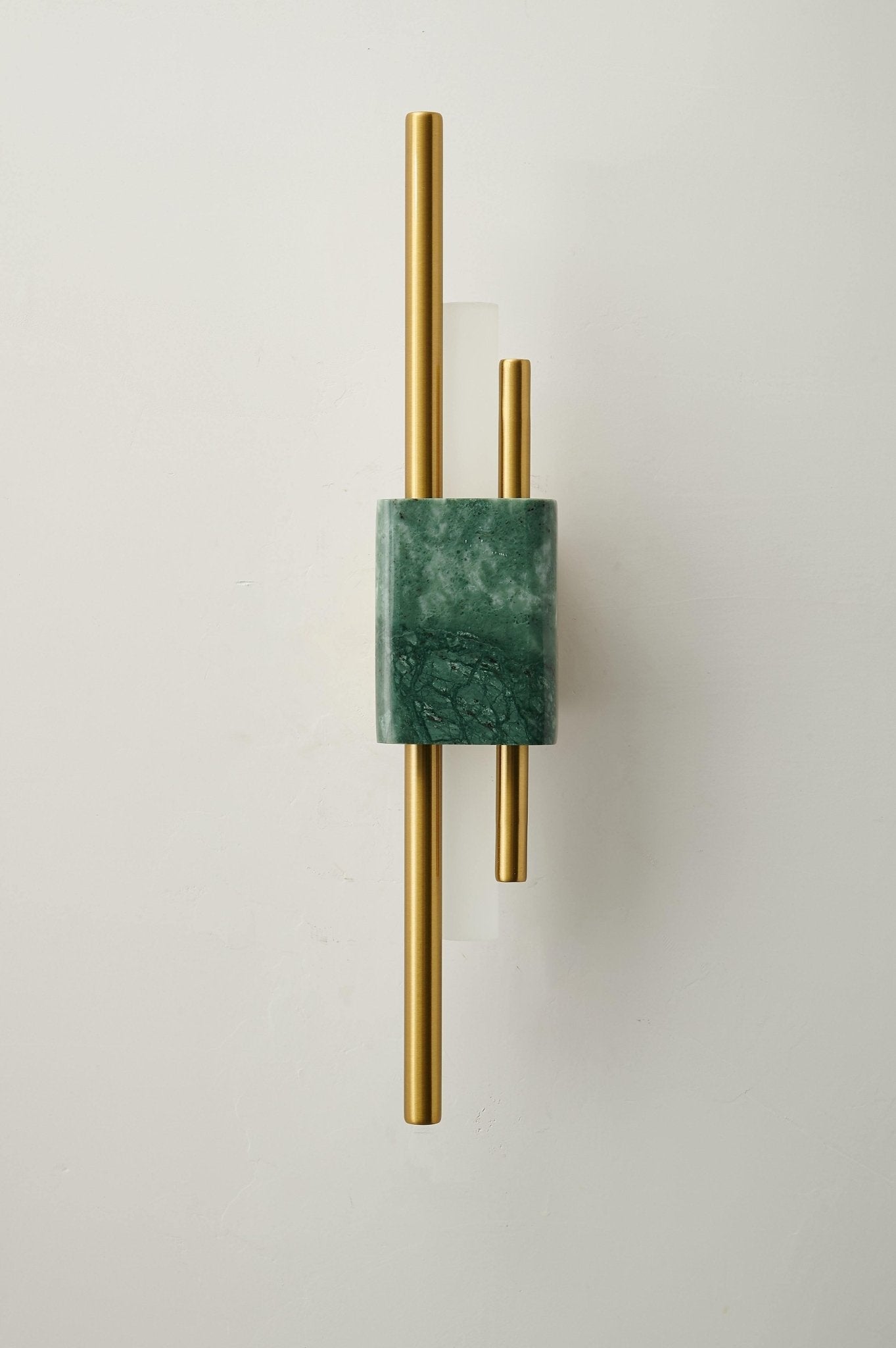 White marble wall sconce illuminating a refined entryway