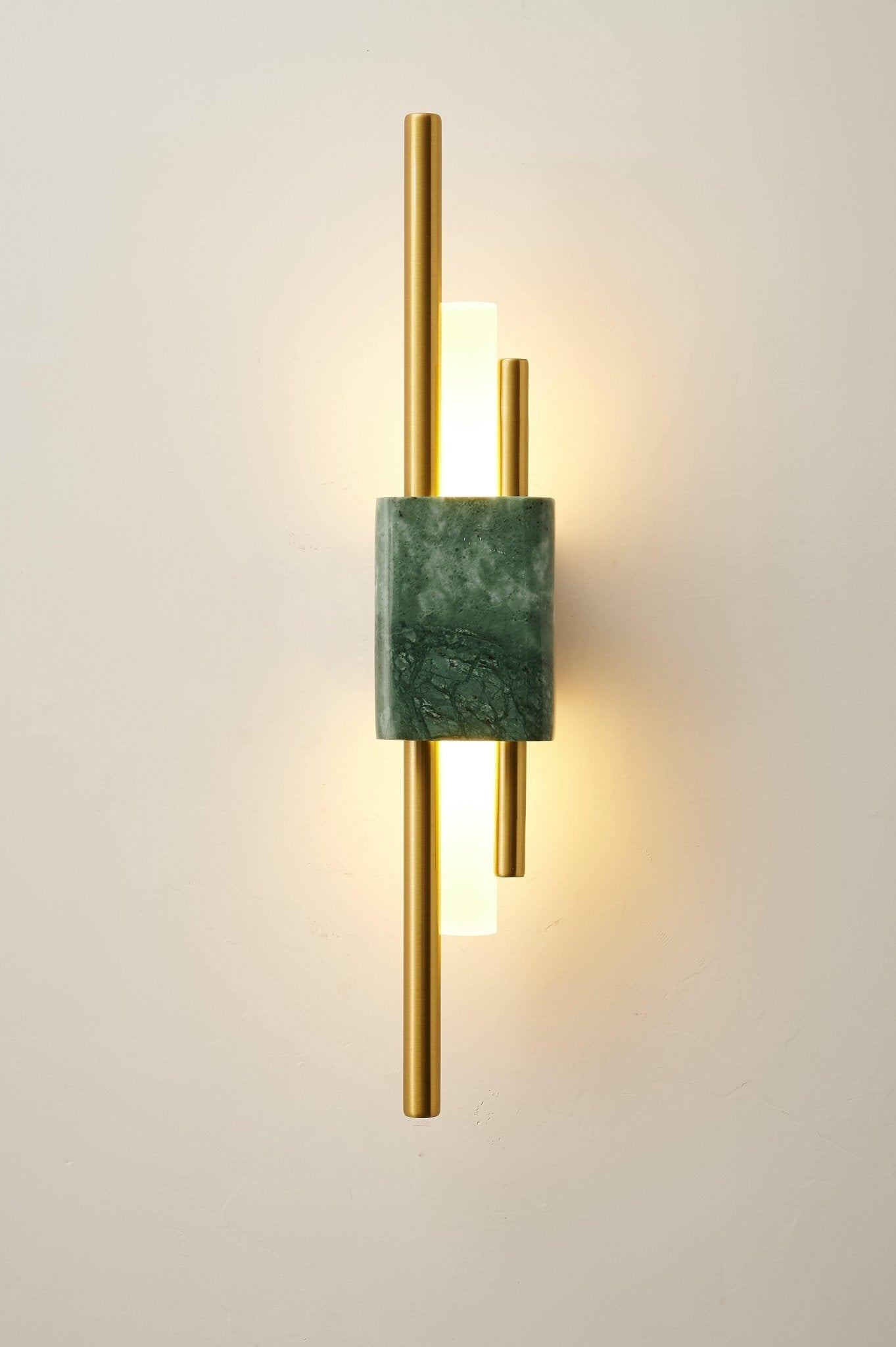 Marble and gold wall lamp glowing in a cozy bedroom scene
