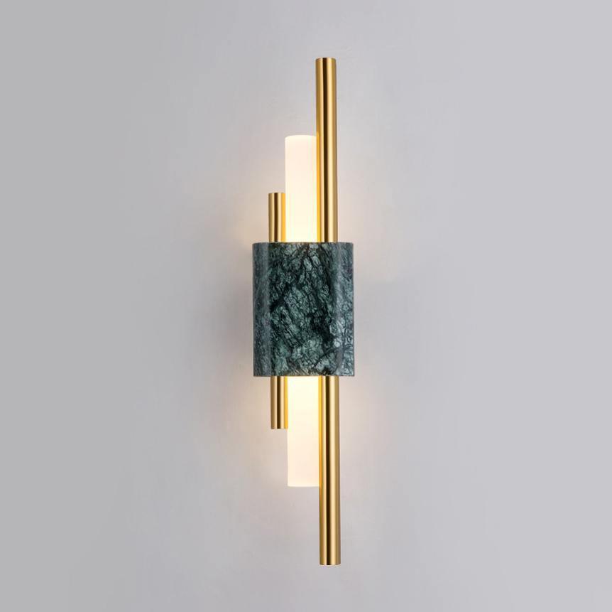 Marble and gold cylinder wall lamp glowing with warm light