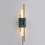 Mounted on a plain wall with its cord hanging visible, this Clérachic wall sconce shows a green marble block between brass rods.