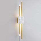 A white marble block sits between glowing brass rods on this Clérachic wall sconce, photographed straight-on against a plain grey wall.