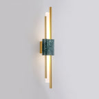 Clérachic wall light with green marble front, lit, mounted plainly on a neutral grey wall.