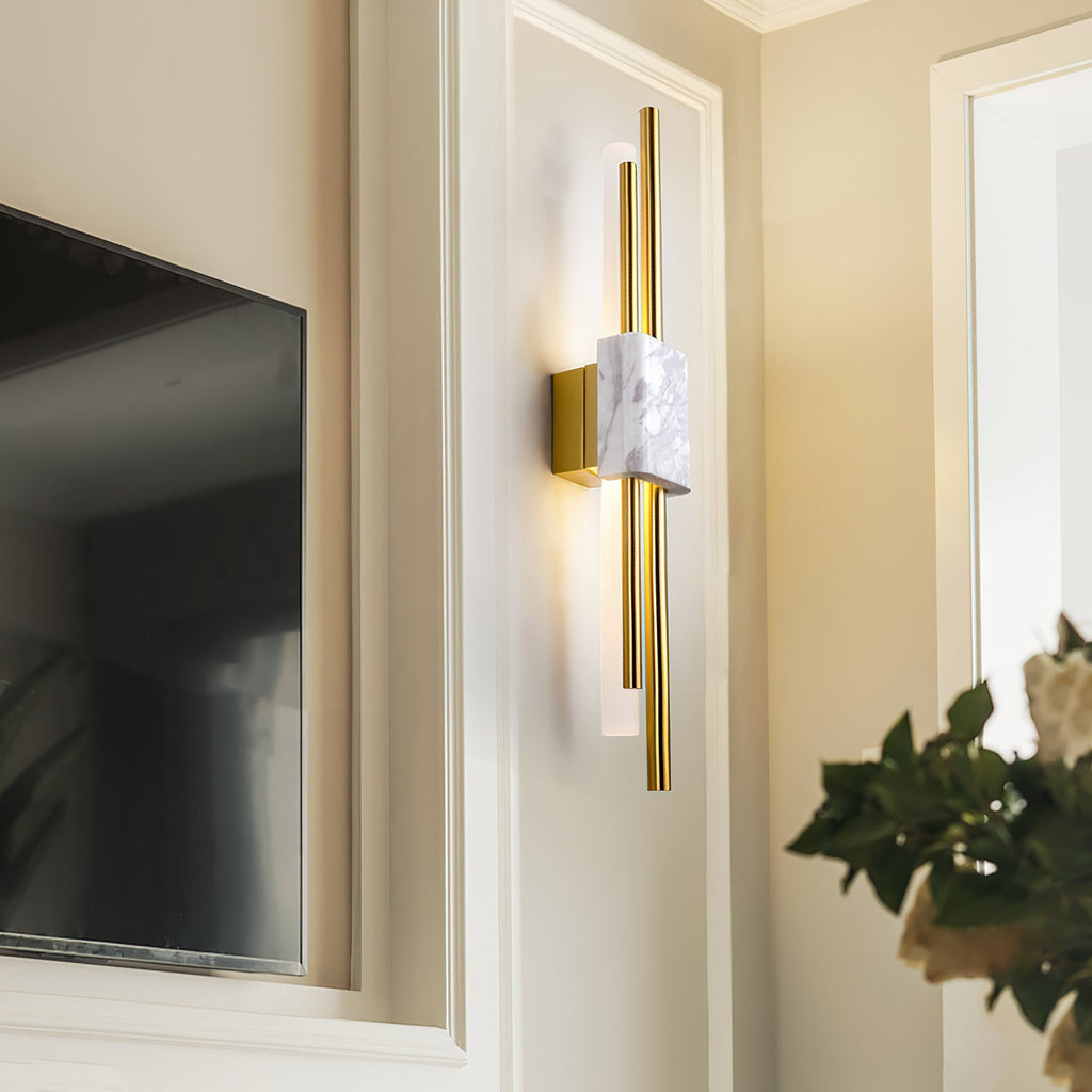 Marble wall lamp with warm light beside a framed picture