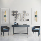 Two Clérachic wall lights frame a wall of decorative mirrored discs in a pale grey study styled with a console and chairs.