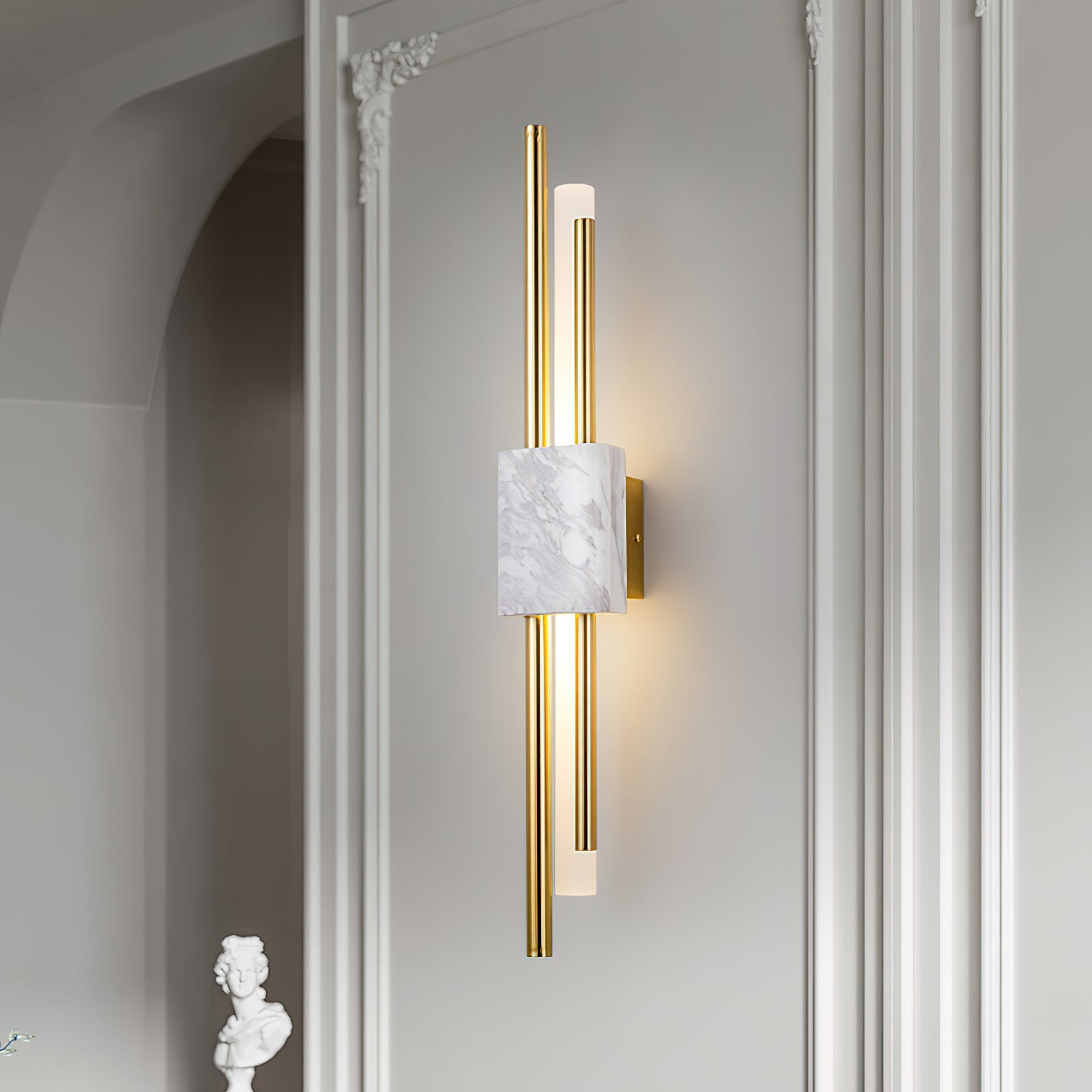 White marble and gold wall sconce on a hallway wall