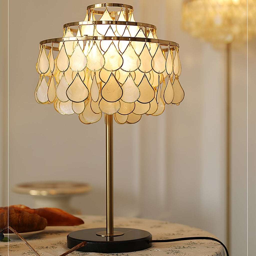 Clérachic table lamp glowing on a round table, croissants and blueberries arranged close to its black marble base.