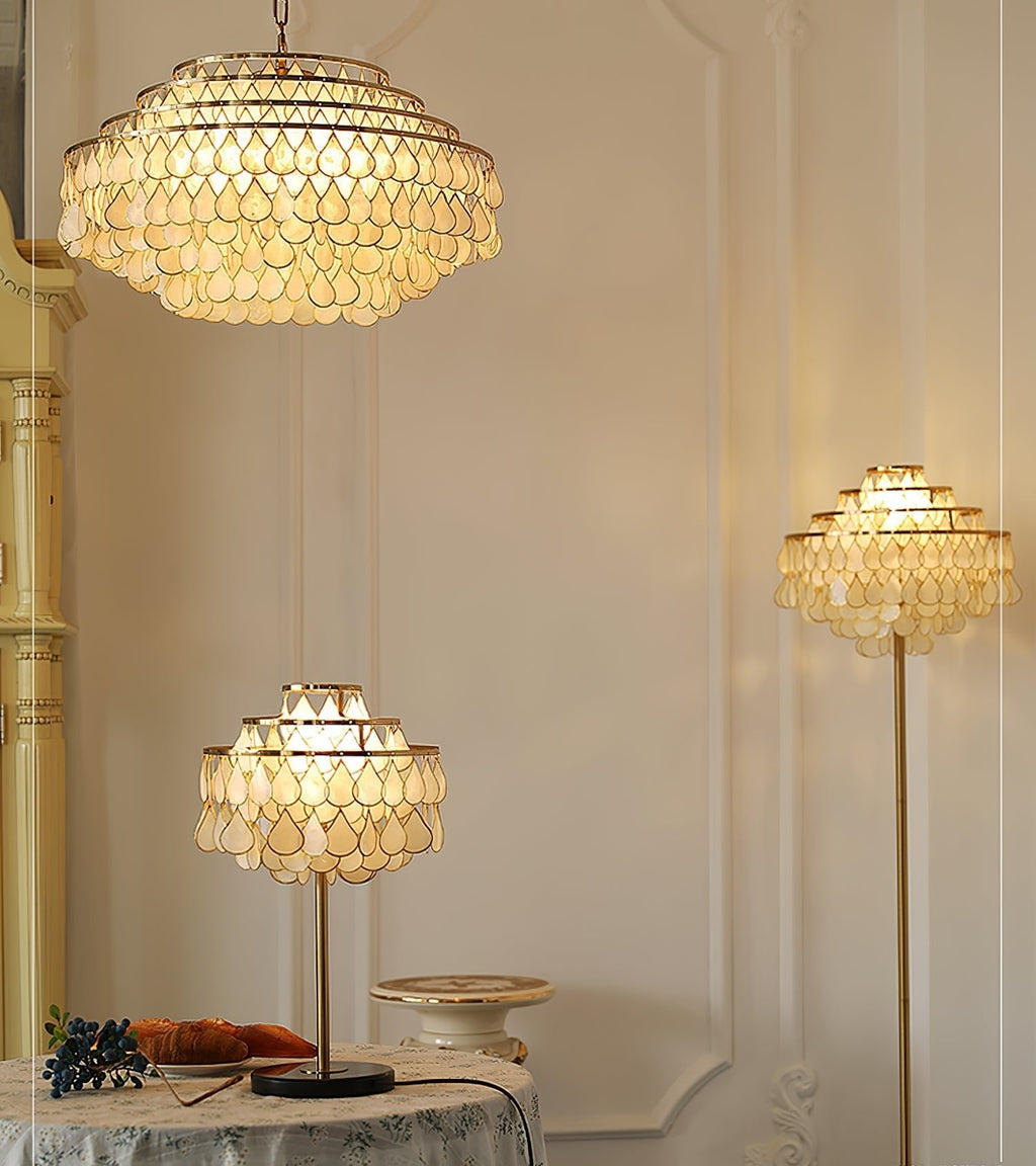 Clérachic table lamp and a taller matching floor lamp glowing together beside a round table draped in white linen.