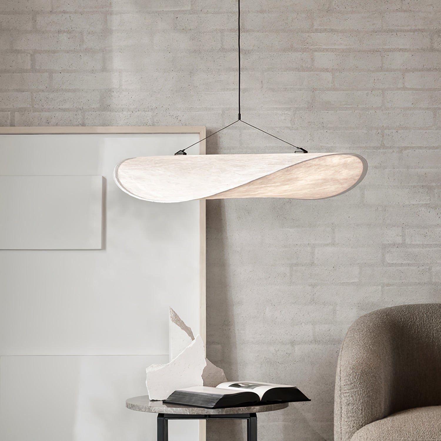 Tyvek pendant lamp glowing softly over a lounge seating area