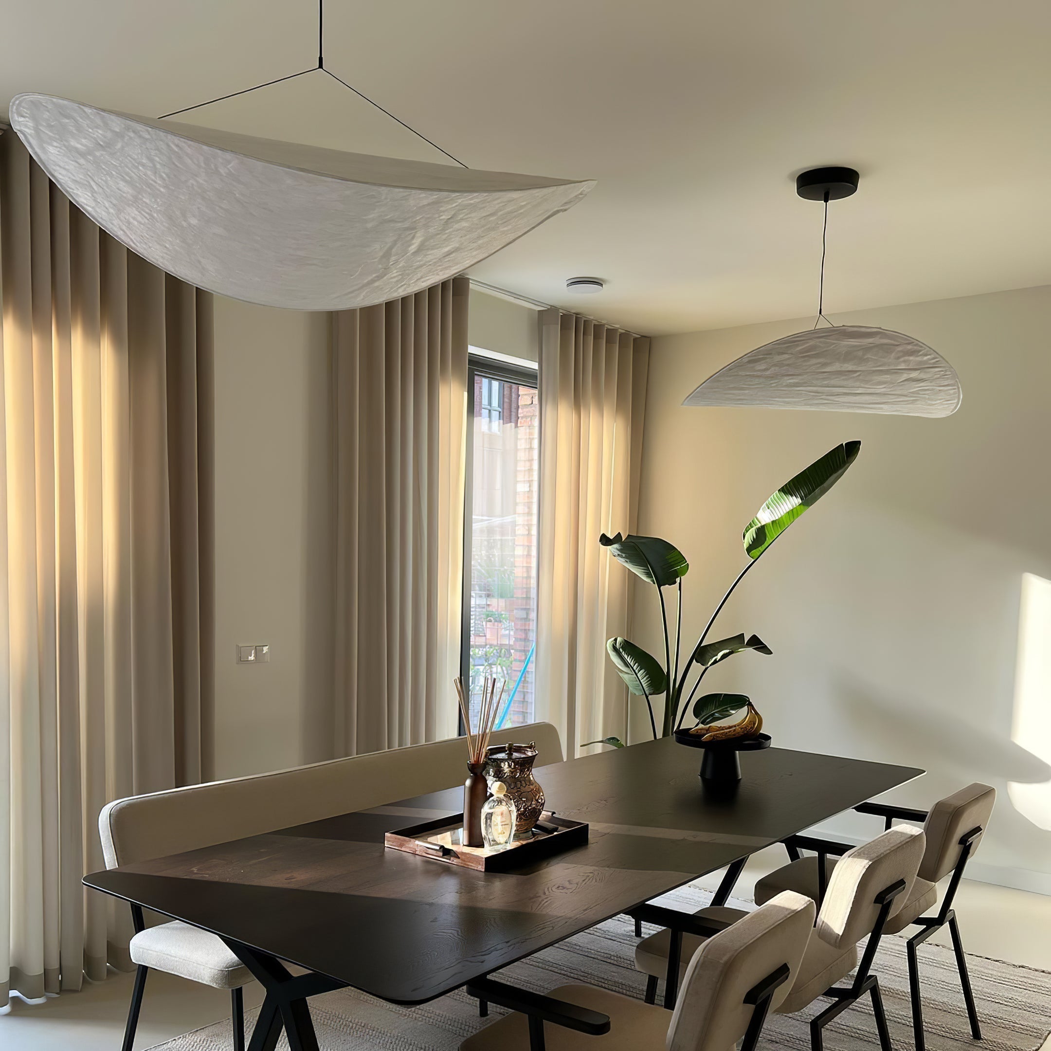 Tyvek paper pendant light glowing warmly above a dining table