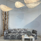 Round silk pendant light glowing softly over a table