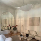 Oversized paper pendant lamp glowing in a tall open interior