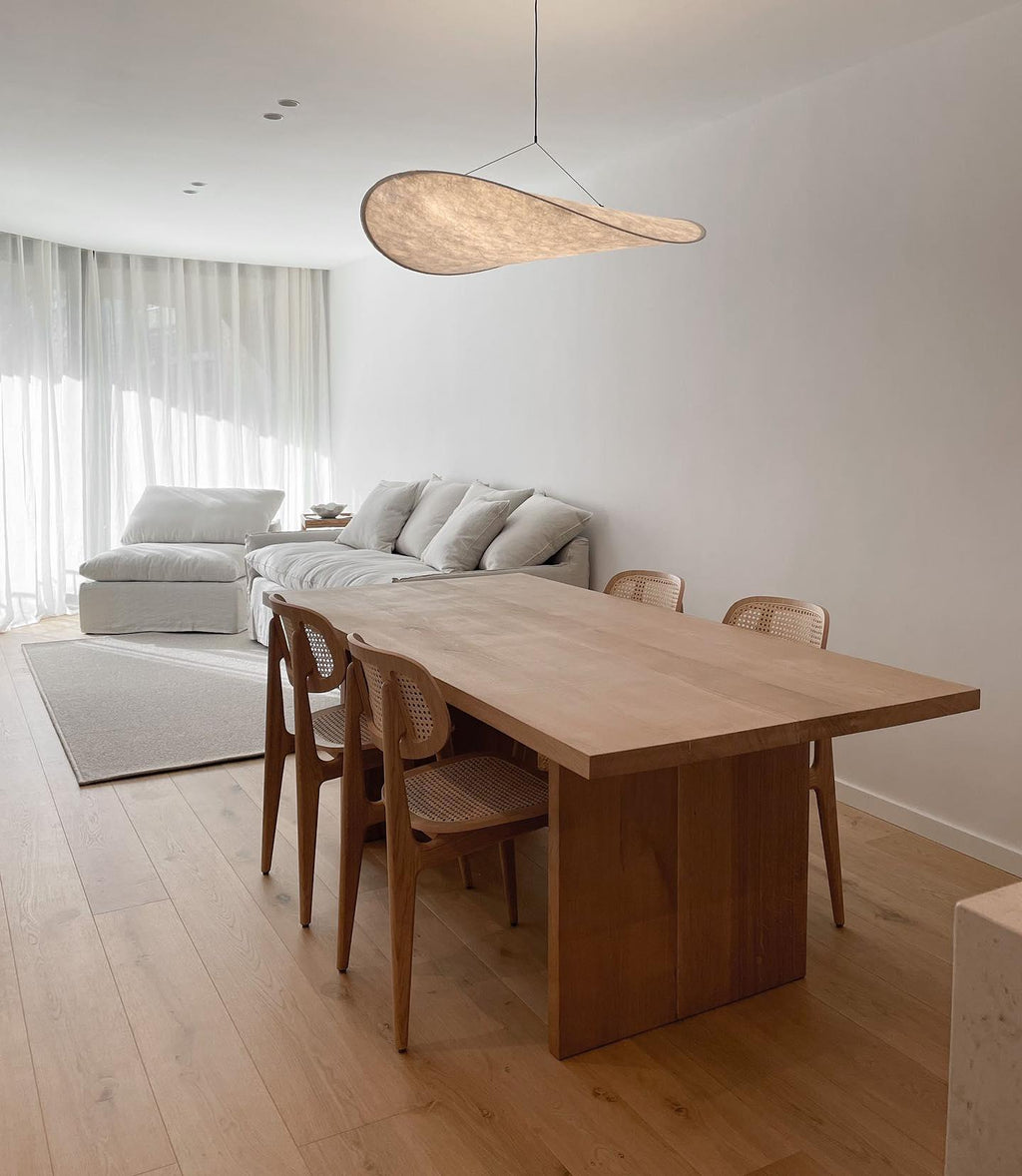 White and black paper pendant lamp hanging above a table