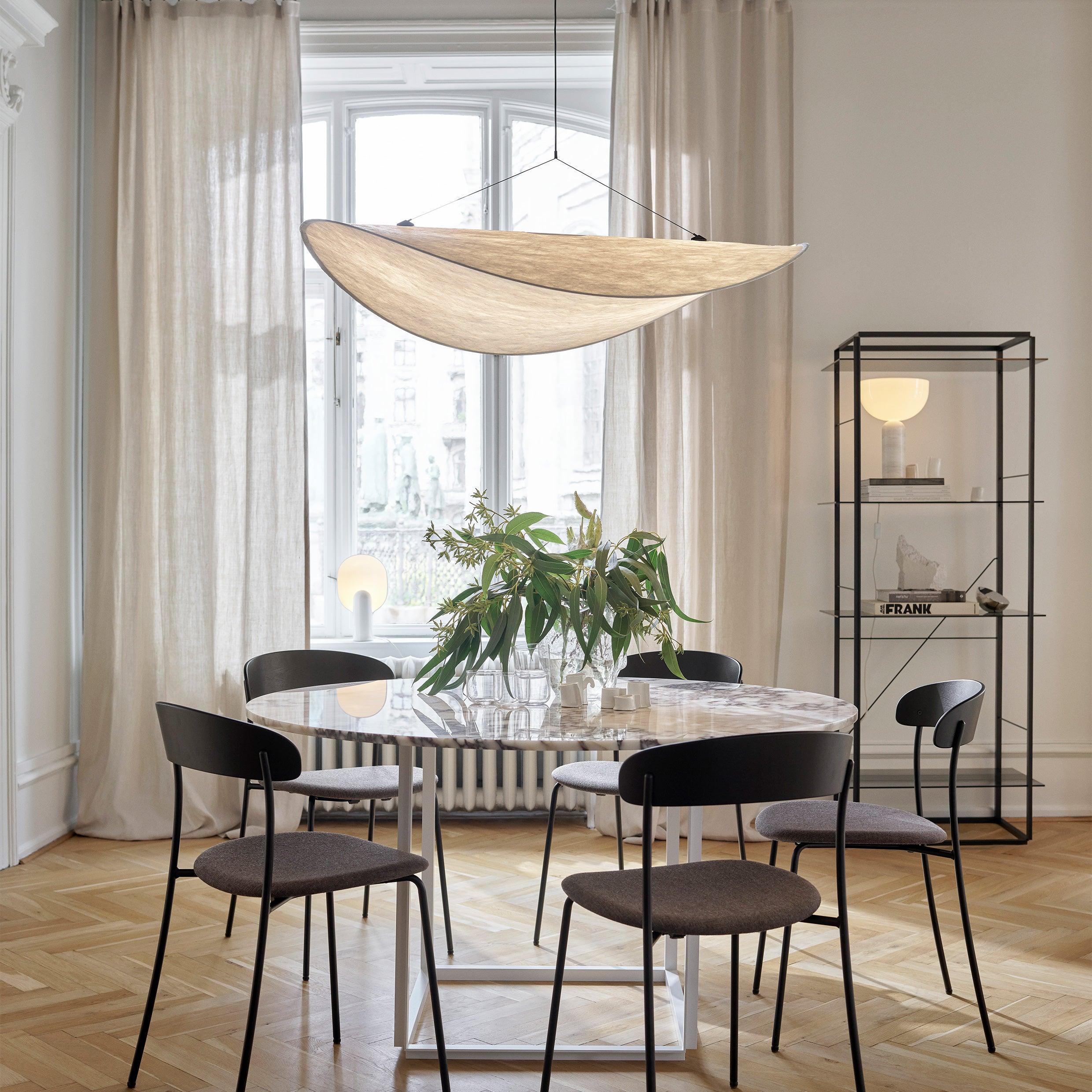 Tyvek pendant light shown hanging in a styled living room