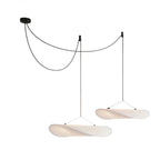 White paper pendant lamp shown against a plain studio wall