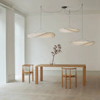 Paper pendant lamp suspended above a minimalist dining space
