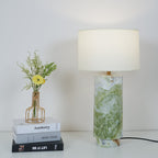 Clérachic table lamp styled again beside the same book stack and flower vase, shown from a slightly wider crop.