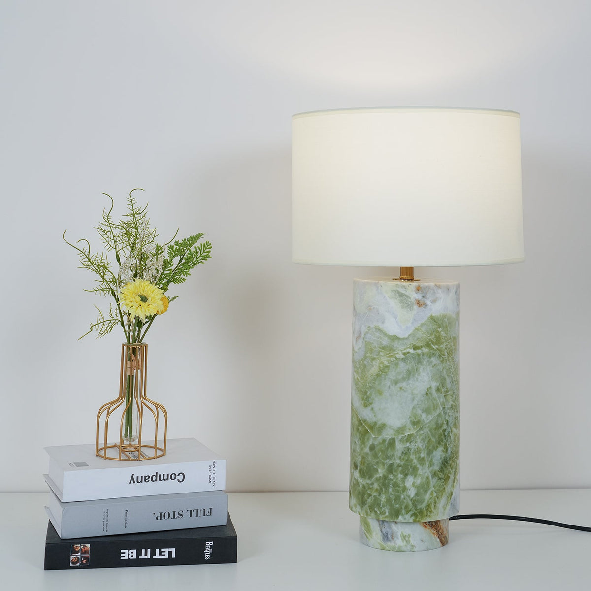 Clérachic table lamp styled again beside the same book stack and flower vase, shown from a slightly wider crop.