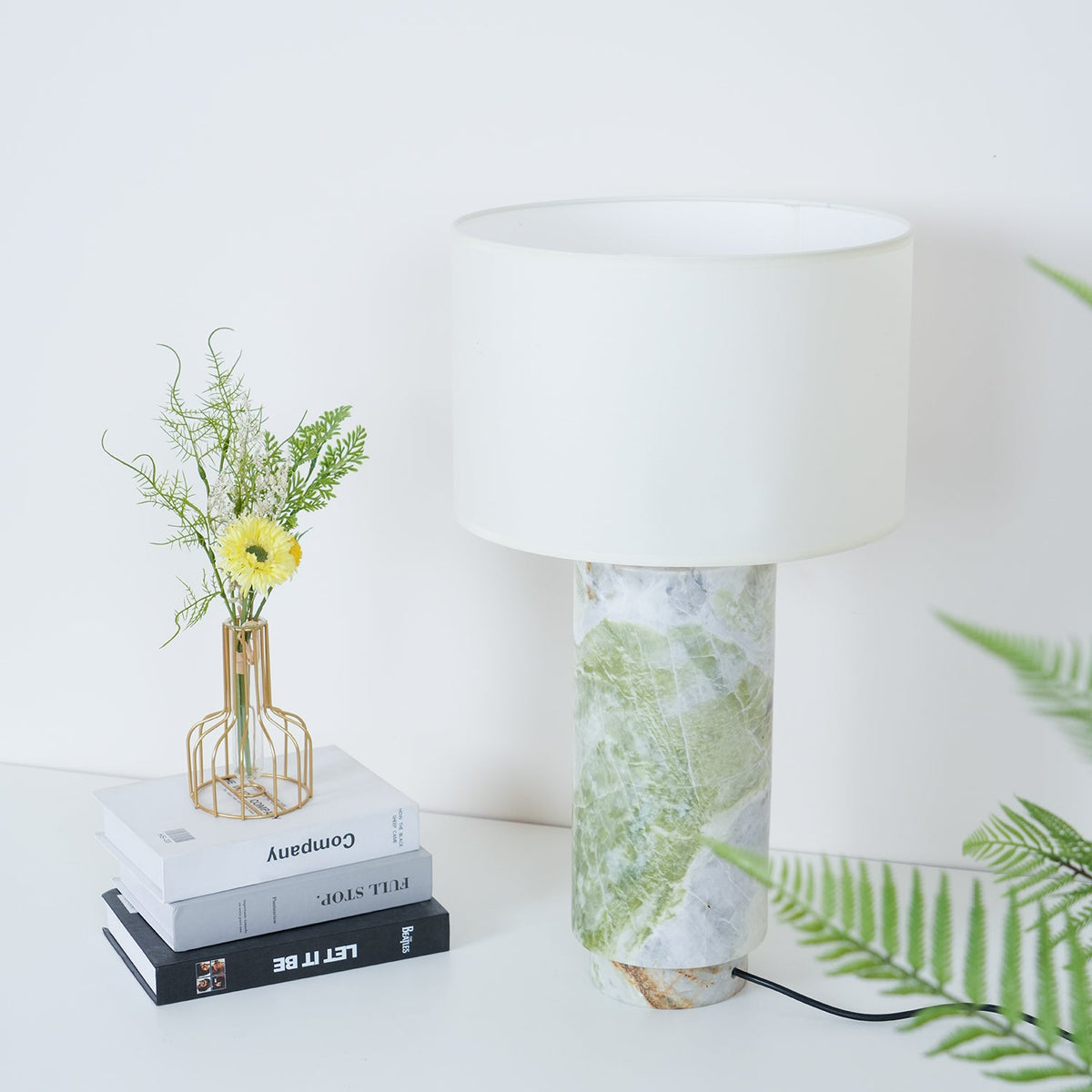 Clérachic table lamp shown closer in, fern fronds and the flower vase visible either side of the marble base.